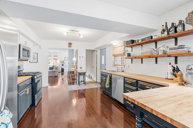 1714 5th St NE, Minneapolis, MN 55413 - kitchen with wood counters, stainless steel appliances, blue cabinetry, a sink, and dark wood-style floors