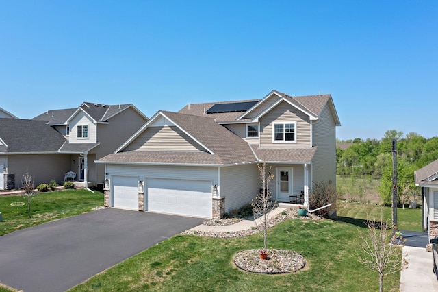 16614 74th St NE, Otsego, MN 55330 - traditional-style home featuring an attached garage, a front lawn, asphalt driveway, solar panels, and stone siding