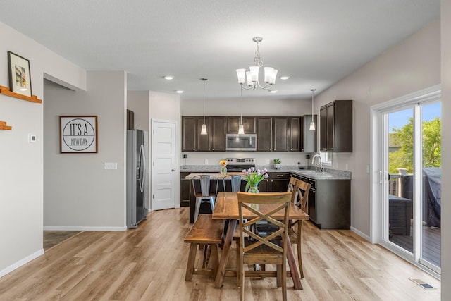 16614 74th St NE, Otsego, MN 55330 - kitchen featuring stainless steel appliances, a sink, dark brown cabinets, a chandelier, and light wood finished floors