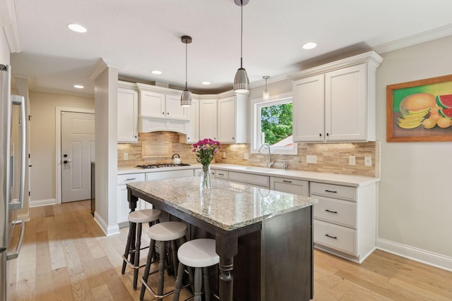 312 Barry Ave N, Wayzata, MN 55391 - kitchen featuring gas cooktop, baseboards, light wood finished floors, crown molding, and recessed lighting