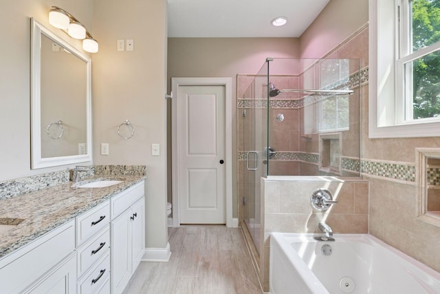 312 Barry Ave N, Wayzata, MN 55391 - full bathroom featuring a tub with jets, double vanity, a stall shower, toilet, and baseboards