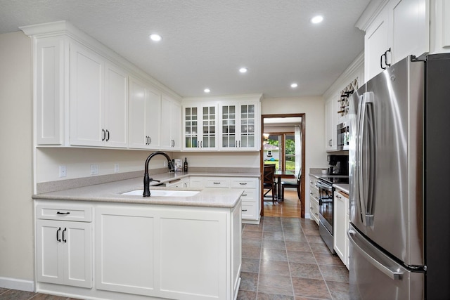 135 Glen Creek Rd NE, Fridley, MN 55432 - kitchen with appliances with stainless steel finishes, a peninsula, white cabinets, glass insert cabinets, and recessed lighting
