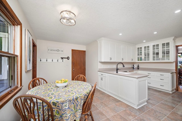135 Glen Creek Rd NE, Fridley, MN 55432 - kitchen featuring light countertops, glass insert cabinets, a peninsula, white cabinets, and recessed lighting