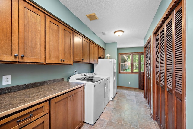 135 Glen Creek Rd NE, Fridley, MN 55432 - laundry area with cabinet space, separate washer and dryer, a textured ceiling, and stone finish flooring