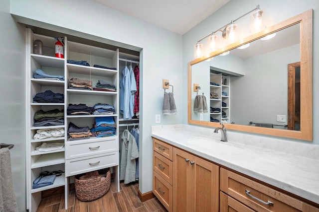 135 Glen Creek Rd NE, Fridley, MN 55432 - bathroom featuring vanity, wood finished floors, and a walk in closet