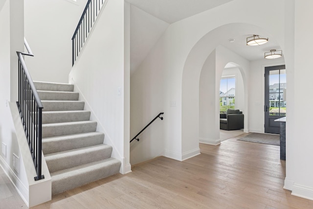 10172 Peony Ln N, Maple Grove, MN 55311 - stairway with arched walkways, wood finished floors, and baseboards