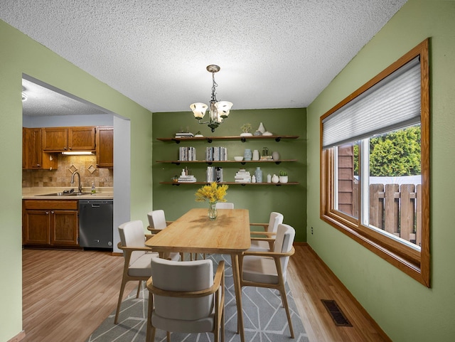 1626 Raindrop Dr, Eagan, MN 55121 - dining room with light wood-style flooring, a chandelier, and a textured ceiling