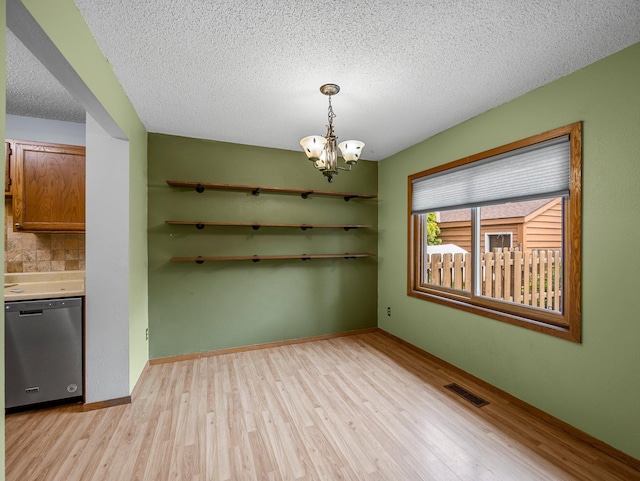 1626 Raindrop Dr, Eagan, MN 55121 - unfurnished dining area featuring light wood-style floors, a chandelier, and a textured ceiling
