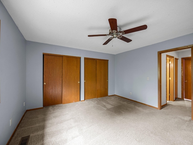 1626 Raindrop Dr, Eagan, MN 55121 - unfurnished bedroom featuring multiple closets, carpet floors, and a ceiling fan