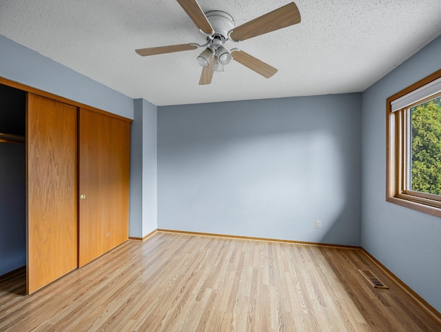 1626 Raindrop Dr, Eagan, MN 55121 - unfurnished bedroom featuring wood finished floors, a closet, a textured ceiling, and ceiling fan