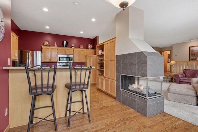 20886 Jenkins Way, Lakeville, MN 55044 - kitchen featuring appliances with stainless steel finishes, open floor plan, a peninsula, open shelves, and light wood finished floors