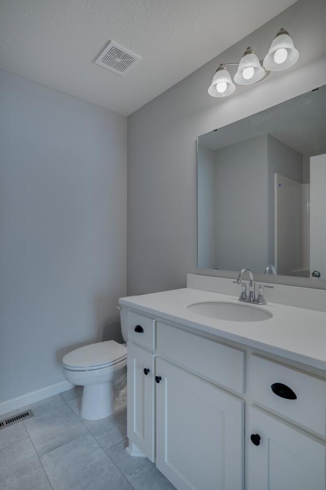 19892 English Ave N, Forest Lake, MN 55025 - bathroom with toilet, vanity, tile patterned floors, a textured ceiling, and baseboards
