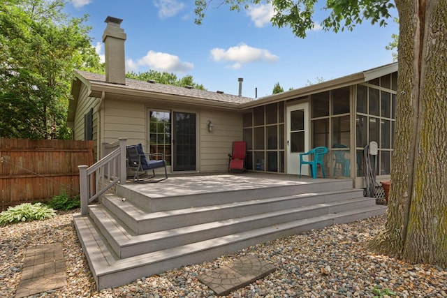432 Garden Rd, Albert Lea, MN 56007 - rear view of house featuring a sunroom, a wooden deck, and a chimney