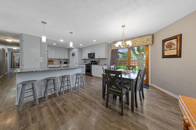 432 Garden Rd, Albert Lea, MN 56007 - dining room with a textured ceiling, a chandelier, dark wood finished floors, baseboards, and recessed lighting