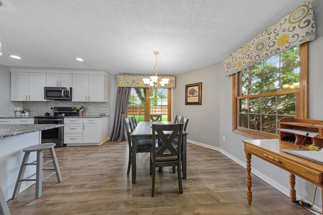 432 Garden Rd, Albert Lea, MN 56007 - dining area with a chandelier, a textured ceiling, plenty of natural light, dark wood-style floors, and recessed lighting