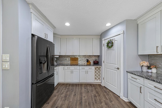 432 Garden Rd, Albert Lea, MN 56007 - kitchen with refrigerator with ice dispenser, dark wood-type flooring, tasteful backsplash, a textured ceiling, and dark stone countertops