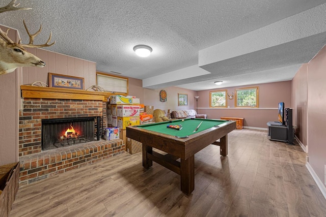 432 Garden Rd, Albert Lea, MN 56007 - game room featuring wood finished floors, pool table, a brick fireplace, a textured ceiling, and baseboards