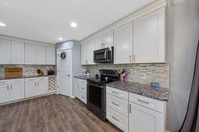 432 Garden Rd, Albert Lea, MN 56007 - kitchen with appliances with stainless steel finishes, dark stone countertops, dark wood-style flooring, recessed lighting, and a textured ceiling