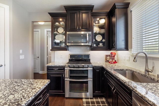 1270 Crosswinds Ct, Waconia, MN 55387 - kitchen featuring stainless steel appliances, a sink, decorative backsplash, and light stone countertops