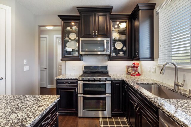 1270 Crosswinds Ct, Waconia, MN 55387 - kitchen with stainless steel appliances, backsplash, light stone countertops, and dark wood-style flooring