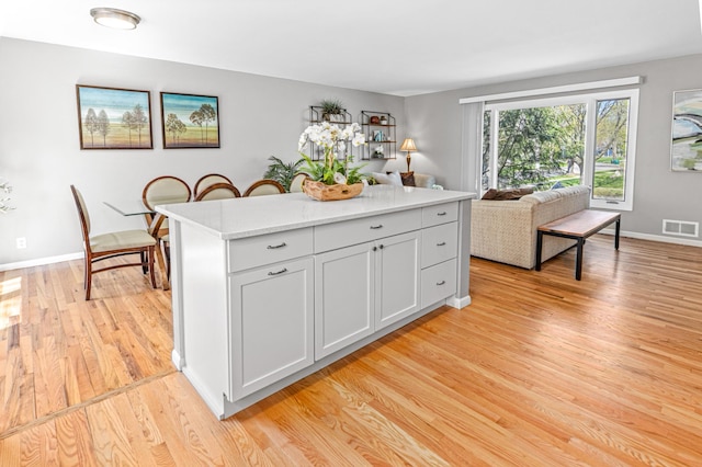 7136 145th St W, Apple Valley, MN 55124 - kitchen with light wood-type flooring, a kitchen island, and baseboards