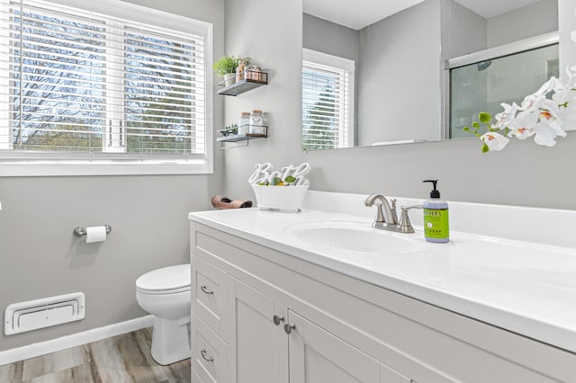 7136 145th St W, Apple Valley, MN 55124 - bathroom featuring toilet, vanity, a shower with shower door, baseboards, and wood finished floors