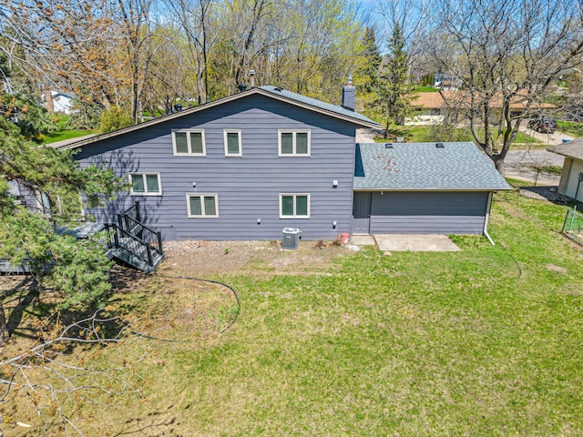 7136 145th St W, Apple Valley, MN 55124 - rear view of house featuring a yard, a chimney, cooling unit, and roof with shingles