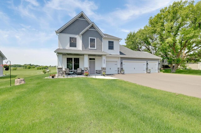 9867 Kahler Ave NE, Monticello, MN 55362 - craftsman inspired home featuring a porch, a front yard, concrete driveway, a garage, and stone siding