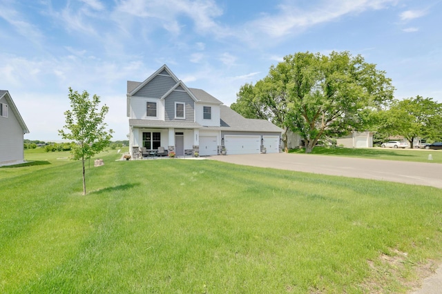 9867 Kahler Ave NE, Monticello, MN 55362 - view of front of house with driveway, a front lawn, an attached garage, and covered porch