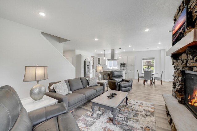 9867 Kahler Ave NE, Monticello, MN 55362 - living room with a fireplace, light wood-type flooring, recessed lighting, and baseboards
