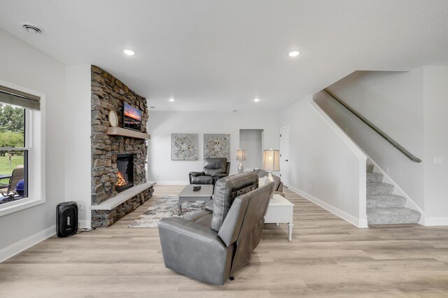9867 Kahler Ave NE, Monticello, MN 55362 - living area featuring stairway, a stone fireplace, baseboards, light wood finished floors, and recessed lighting