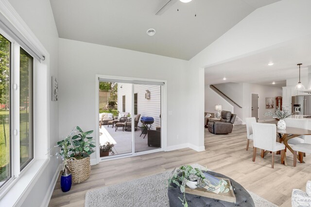 9867 Kahler Ave NE, Monticello, MN 55362 - living area featuring plenty of natural light, light wood-style floors, baseboards, ceiling fan, and high vaulted ceiling