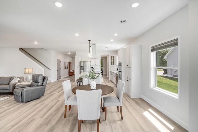 9867 Kahler Ave NE, Monticello, MN 55362 - dining area featuring baseboards, light wood-type flooring, recessed lighting, and stairs