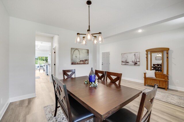9867 Kahler Ave NE, Monticello, MN 55362 - dining room with light wood-style flooring, a chandelier, and baseboards