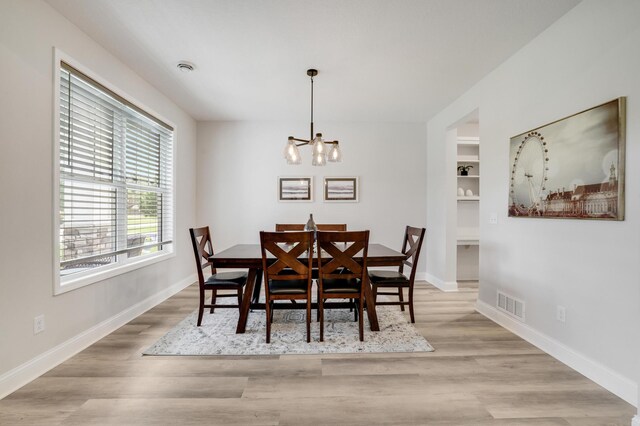 9867 Kahler Ave NE, Monticello, MN 55362 - dining room with a chandelier, light wood finished floors, and baseboards