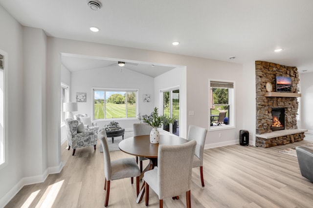 9867 Kahler Ave NE, Monticello, MN 55362 - dining area with light wood finished floors, healthy amount of natural light, a stone fireplace, vaulted ceiling, and recessed lighting