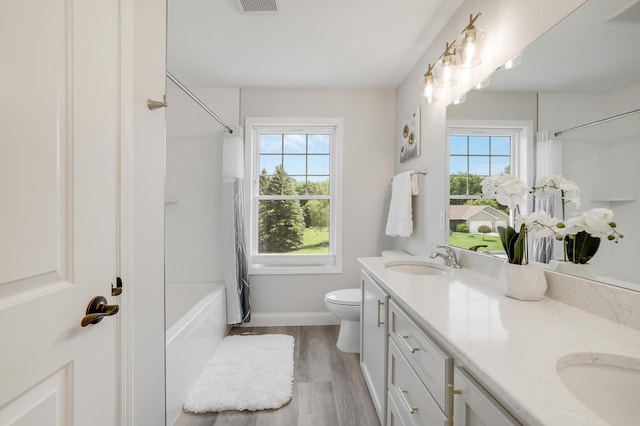 9867 Kahler Ave NE, Monticello, MN 55362 - full bath with double vanity, shower / tub combo with curtain, baseboards, toilet, and wood finished floors