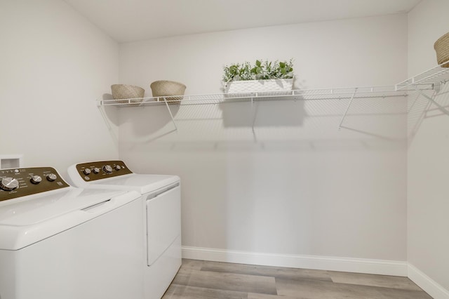 9867 Kahler Ave NE, Monticello, MN 55362 - laundry area with washing machine and clothes dryer, light wood-type flooring, and baseboards