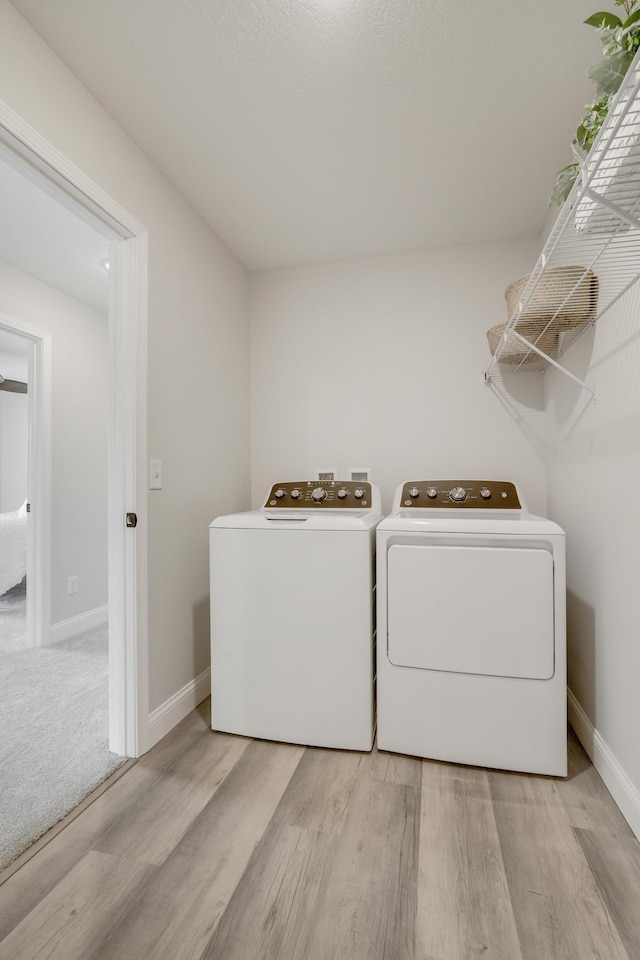 9867 Kahler Ave NE, Monticello, MN 55362 - laundry room with washer and clothes dryer, light wood-type flooring, and baseboards