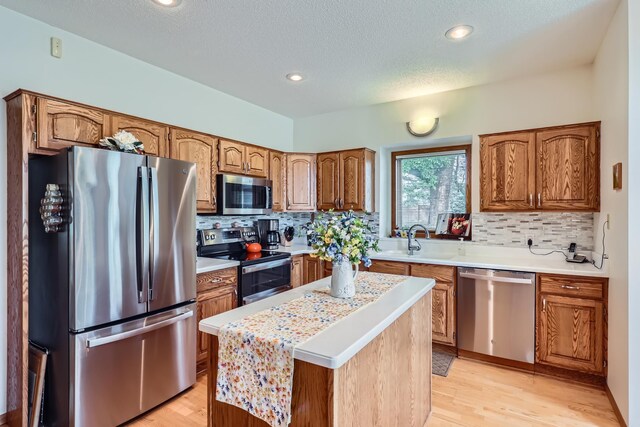 11760 88th Pl N, Maple Grove, MN 55369 - kitchen featuring appliances with stainless steel finishes, brown cabinets, light countertops, tasteful backsplash, and a textured ceiling