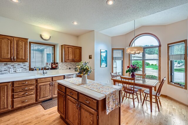 11760 88th Pl N, Maple Grove, MN 55369 - kitchen featuring brown cabinets, light countertops, backsplash, light wood-style floors, and a textured ceiling