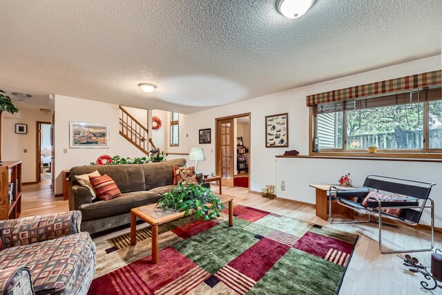 11760 88th Pl N, Maple Grove, MN 55369 - living area featuring a textured ceiling, light wood finished floors, and stairs