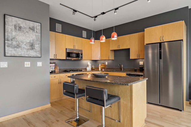 215 10th Ave S Unit 425, Minneapolis, MN 55415 - kitchen with stainless steel appliances, rail lighting, light wood-type flooring, and a breakfast bar area