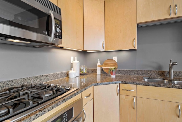 215 10th Ave S Unit 425, Minneapolis, MN 55415 - kitchen featuring stainless steel microwave, light brown cabinets, dark stone counters, and gas cooktop