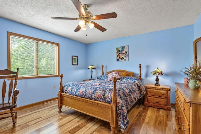1201 Maplewood Dr, Delano, MN 55328 - bedroom featuring wood finished floors, baseboards, a textured ceiling, and ceiling fan