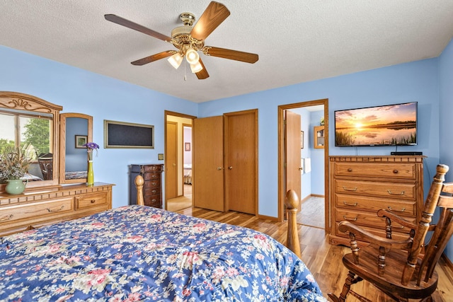 1201 Maplewood Dr, Delano, MN 55328 - bedroom with wood finished floors, a textured ceiling, baseboards, and a ceiling fan