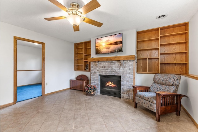 1201 Maplewood Dr, Delano, MN 55328 - living area featuring baseboards, a brick fireplace, built in shelves, a ceiling fan, and light tile patterned flooring