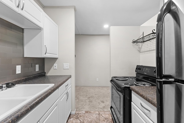 666 Ashland Ave Unit 5, Saint Paul, MN 55104 - kitchen with freestanding refrigerator, black range with electric stovetop, dark countertops, white cabinetry, and recessed lighting