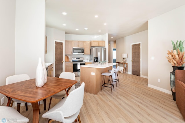 1600 5th Ave NE, Dilworth, MN 56529 - kitchen featuring appliances with stainless steel finishes, light brown cabinetry, light wood finished floors, a kitchen island, and recessed lighting