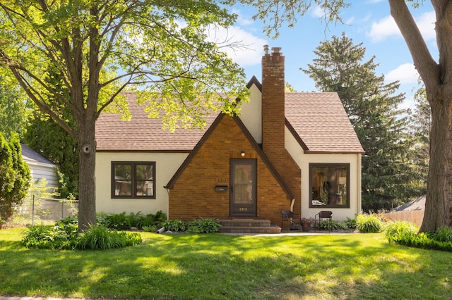 4313 Arthur St NE, Columbia Heights, MN 55421 - tudor house featuring stucco siding, a chimney, and roof with shingles